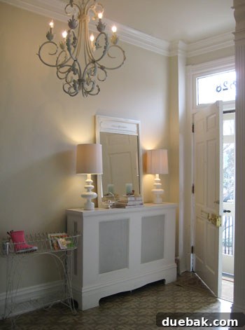Chic and welcoming entryway in Katie Ukrop's home with stenciled floors and elegant furnishings
