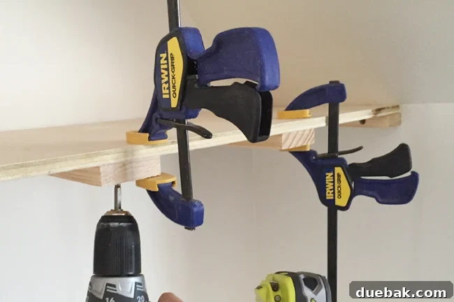 Screwing on a top plywood piece for thin floating shelves using Irwin Quick Grip clamps to hold it in place
