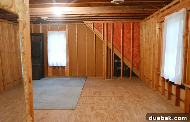 Bonus Room Glow Up 21 Unfinished attic storage room with exposed studs and curtained windows