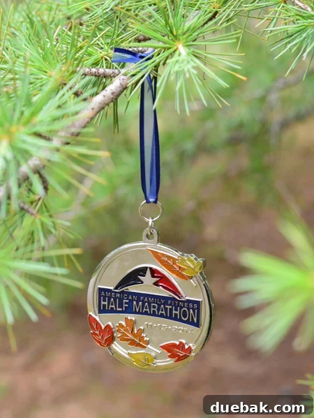Cherished Miles, Festive Shine: Crafting Medal Ornaments 7 Half marathon running race medal thoughtfully hung on a pine tree branch, resembling a Christmas tree