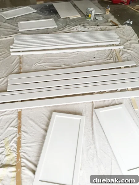 Tailored Book Nooks DIY Built Ins 15 Painted wood pieces, including cabinet doors, shelves, and trim, laid out to dry for the bookshelf project