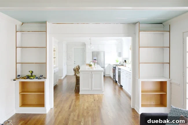 Tailored Book Nooks DIY Built Ins 17 Two side bookshelves meticulously constructed on either side of a doorway, forming the structural base for the complete built-in unit