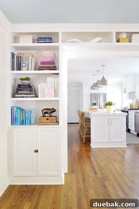 Tailored Book Nooks DIY Built Ins 22 Tastefully decorated built-in bookshelves flanking an opening to a kitchen, highlighting the functional and aesthetic integration