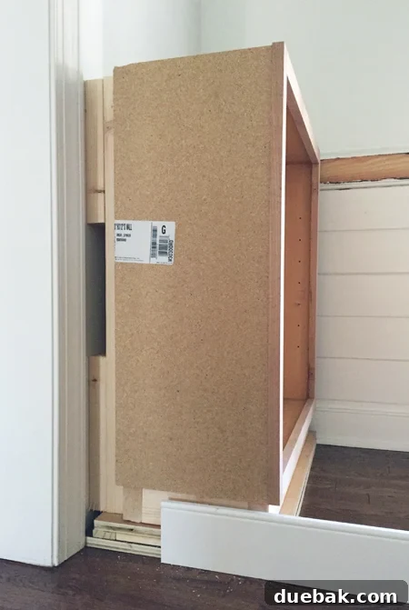 Tailored Book Nooks DIY Built Ins 10 Detailed view of wood blocking behind and under a base cabinet, demonstrating how depth and height are adjusted for built-in shelves