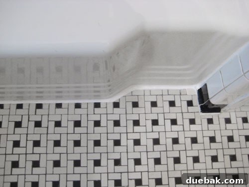 The Secret to Flawless Caulk Lines 5 Hand smoothing a newly applied caulk line with a finger, with painter's tape defining the crisp edge