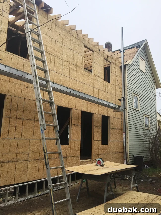 From Studs Up: The Beach House Revival 18 Exterior view of the beach house with the reconstructed side, showing new framing and window openings.