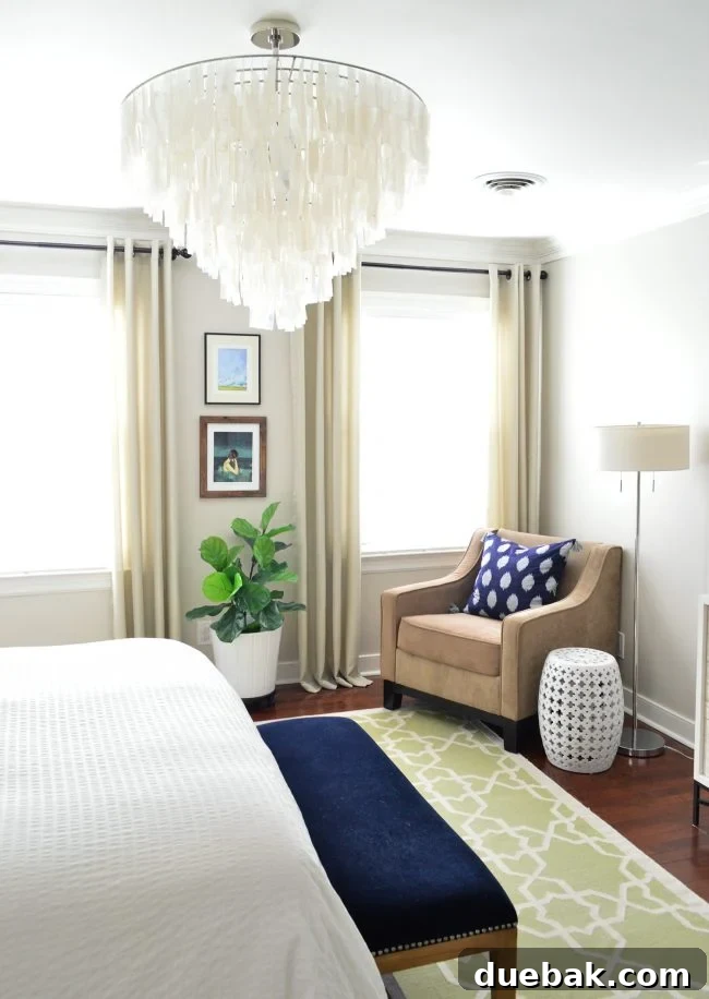 Light Up Your Sleep: Bedroom Refresh with a Chandelier and New Bed 2 Cozy and inviting master bedroom with a large bed, stylish lighting, and comfortable seating areas.