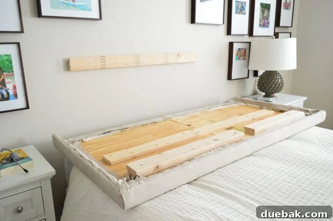 Light Up Your Sleep: Bedroom Refresh with a Chandelier and New Bed 13 Demonstration of the cleat system, showing one board attached to the wall.