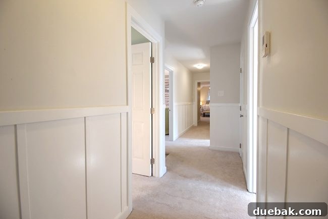 Hallway featuring a newly installed white board and batten wall treatment