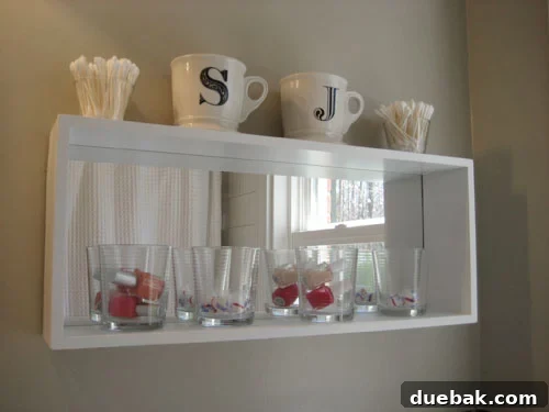 Monogrammed Bathroom Storage Ideas 3 Anthropologie initial mugs holding cotton balls and dental floss on a bathroom counter.