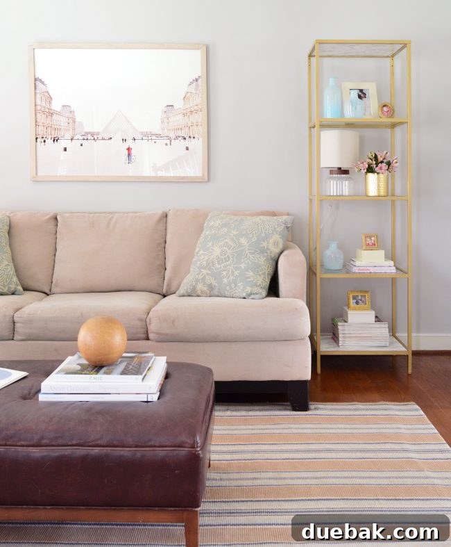 Neutral living room featuring stunning gold display shelves flanking the sofa, adorned with carefully curated accessories and a prominent large-scale art piece.