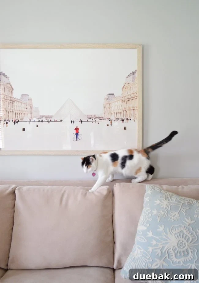 Elegant neutral living room featuring a large Minted Paris art piece on the back wall, creating a sophisticated focal point.