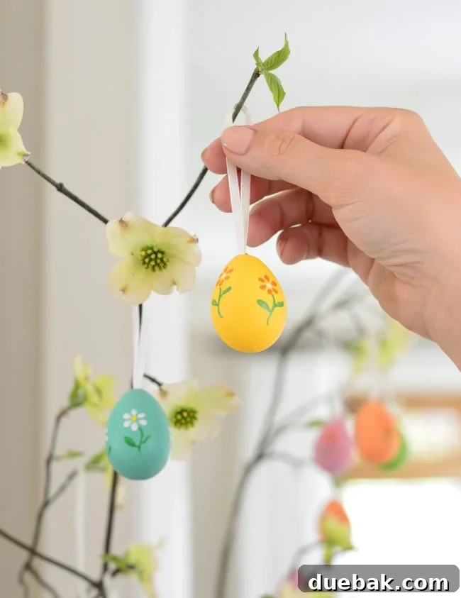 placing decorative painted egg on Easter Tree