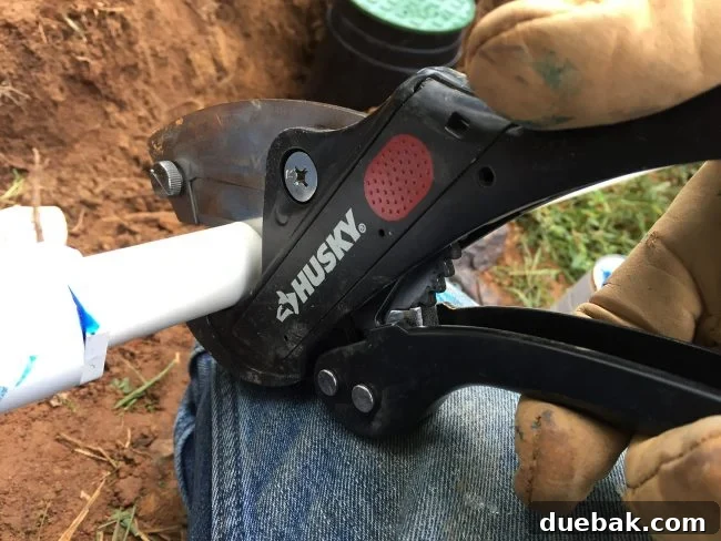 Using a Husky ratcheting pipe cutter to make a clean cut on a PVC pipe for irrigation