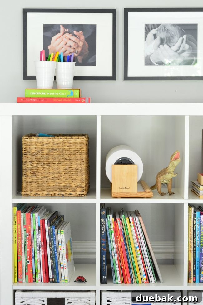 Close-up of framed baby photos on wall above bookcase
