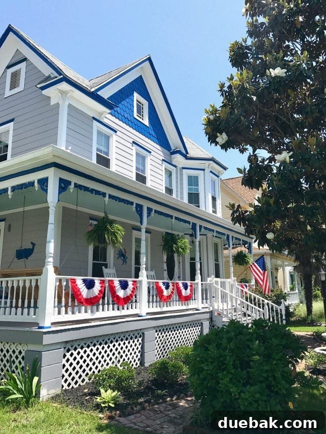 Patriotic Curb Appeal 5 A charming patriotic front porch on a gray-blue beach home, adorned with festive decor and an inviting aura, perfect for coastal living.