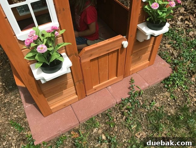 Backyard Discoveries cedar playhouse with red paver base for stability and longevity