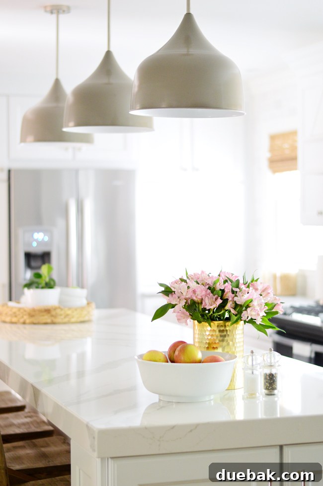 Example of a white kitchen with large gray pendant lights featuring solid shades