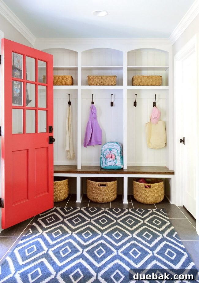 Stylish mudroom with orange door, round baskets, and hooks