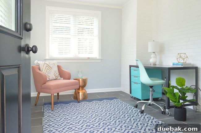 Small office nook with pink chair, blue filing cabinet, and brick wall