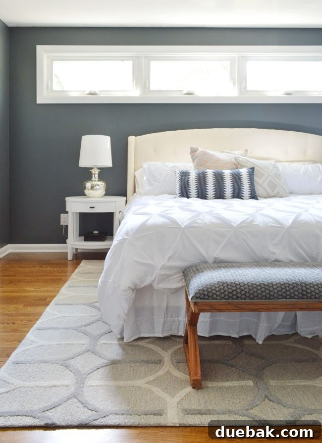 Luxurious master bedroom with grey walls, white bedding, and elegant furniture