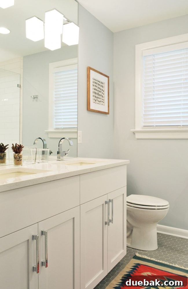 Bathroom with gray hex floors, framed art, and ample storage