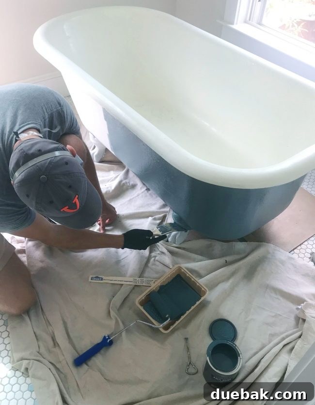 Applying Riverway paint to the intricately detailed feet of a clawfoot tub