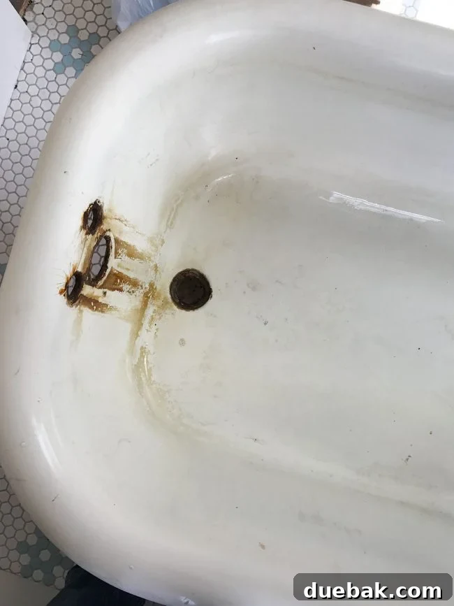 Slightly cleaner white interior of the clawfoot tub after the initial vinegar wash