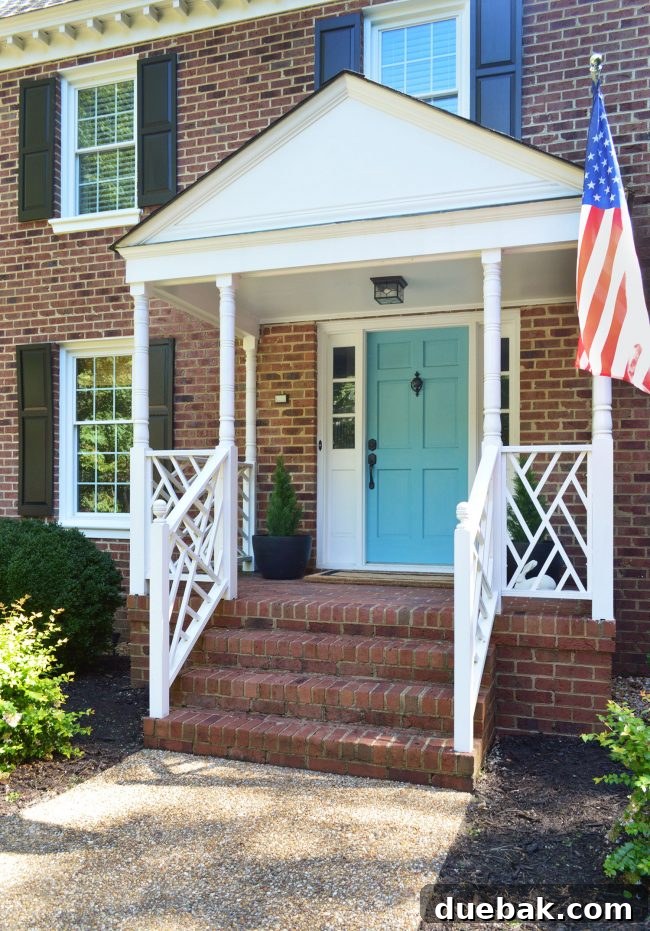 Fully refreshed front porch with a teal blue door and faux evergreen plants