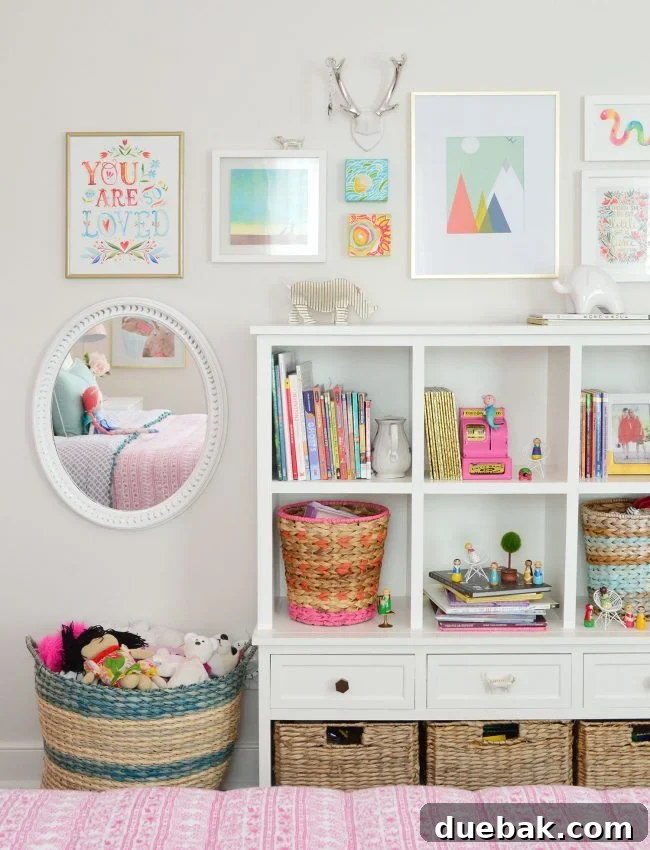 Girls bedroom bookcase functioning as a play area with gallery frames