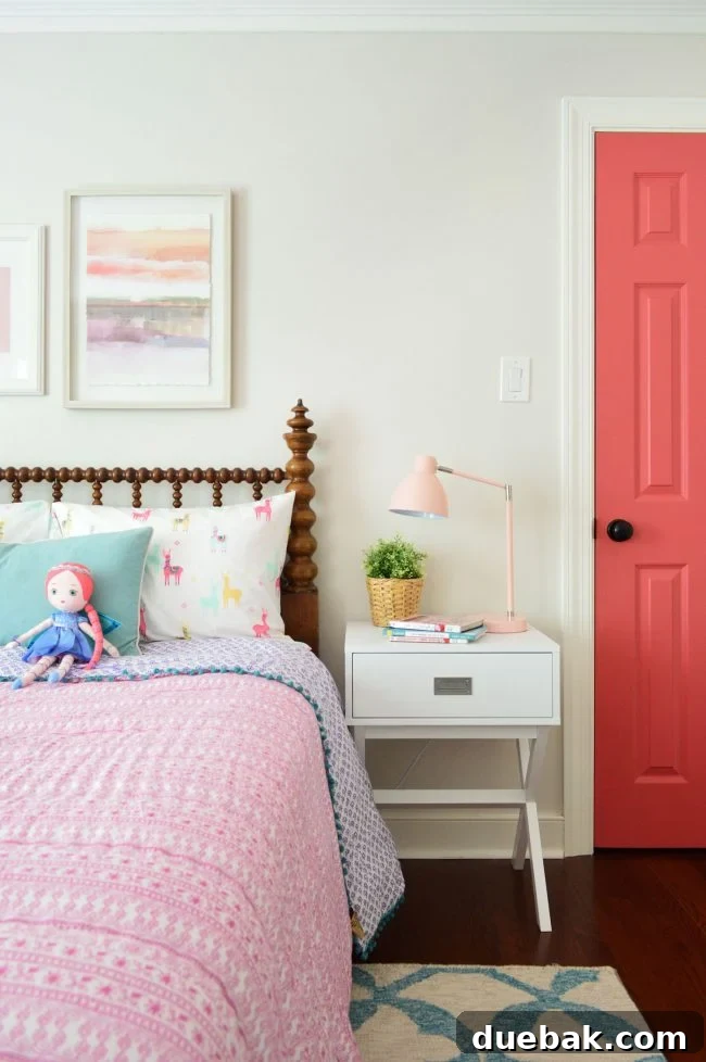 Close-up of the antique wooden spool headboard and campaign sidetable in the girls bedroom