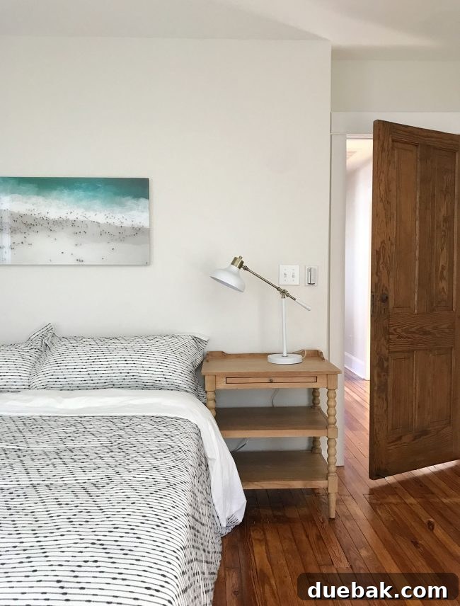 Coastal Comforts Await 10 Master bedroom with bed, nightstands, and art