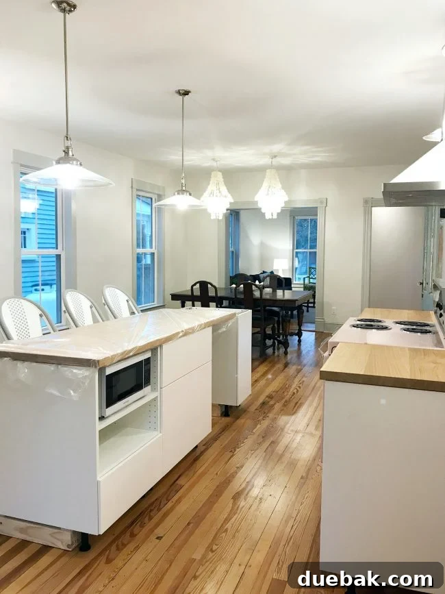 Partially completed beach house kitchen with table, chairs, and chandeliers