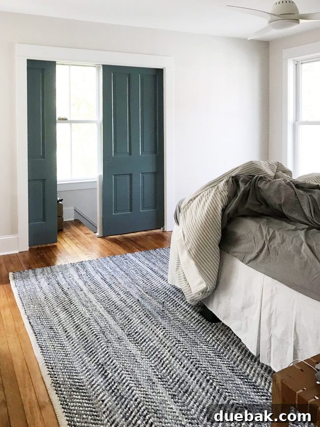 Master bedroom with a dark blue rug that was returned