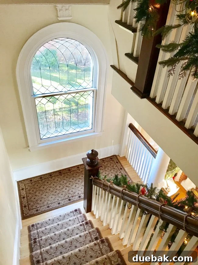 An ornate historical window on a staircase landing inside a Cape Charles B&B