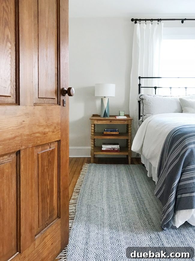 bed in front of window with original pine door