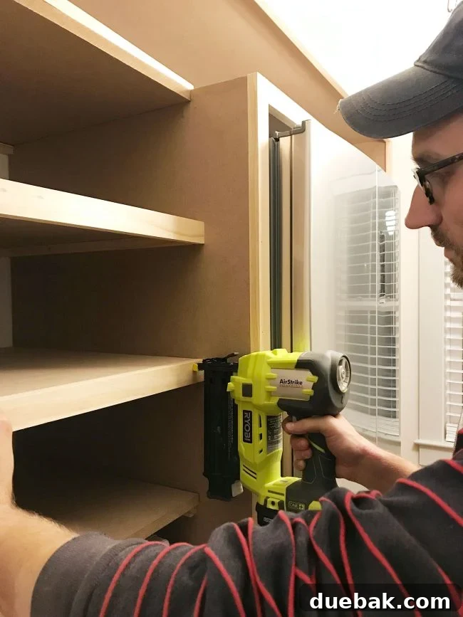 John nailing face pieces onto pantry shelves