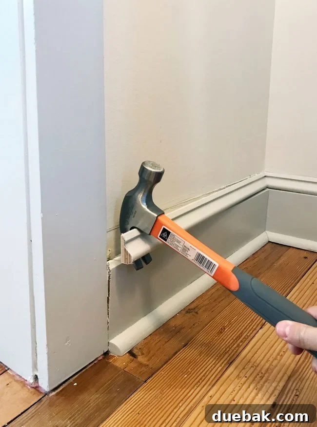 hammer prying off baseboard molding in pantry