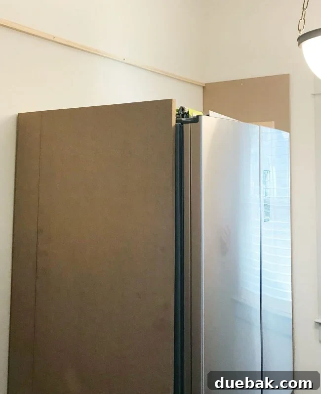 large MDF pieces added vertically against fridge in pantry