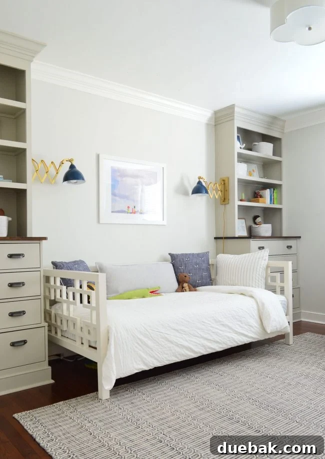Transforming Our Son's Space 2 Boy's bedroom with daybed, blue bee pillows, and brass sconces