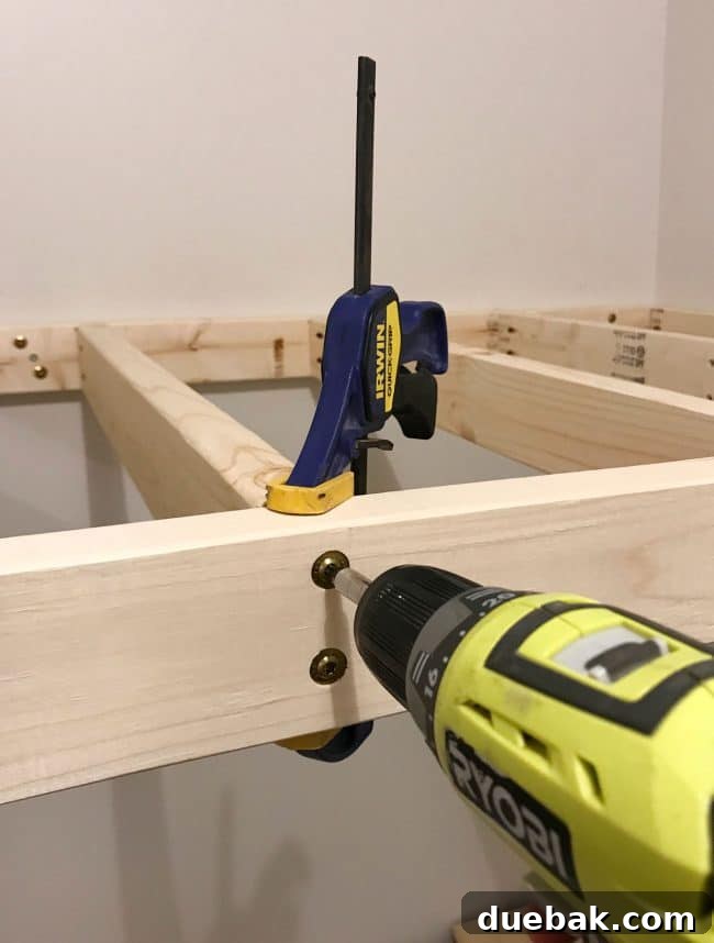 Constructing Bespoke Bunk Beds 16 Using strong bar clamps to hold upper bunk supports in place against the wall while drilling them into position.