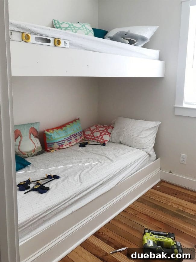 Constructing Bespoke Bunk Beds 18 White trim pieces carefully added to the front face of both bunk bed platforms, showcasing the clean, finished look.