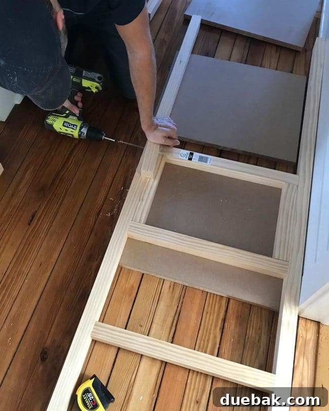 Constructing Bespoke Bunk Beds 21 A person expertly screwing 2x2 wood pieces together to construct the bunk bed ladder, showcasing precise joinery.