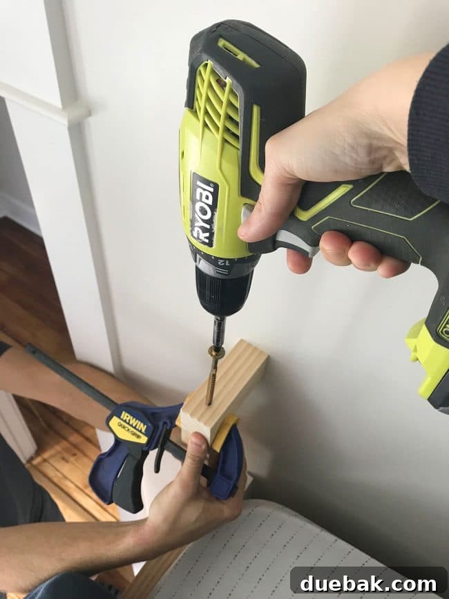 Constructing Bespoke Bunk Beds 24 A Ryobi drill attaching a short top railing piece using RSS screws on the wall side of the bunk bed ladder.
