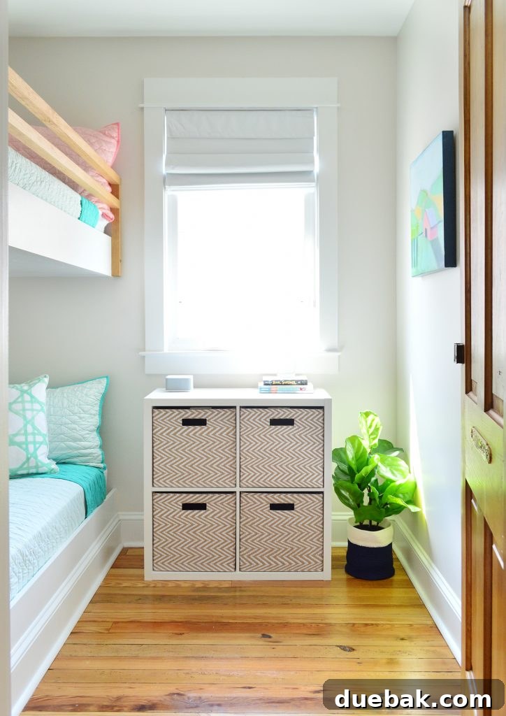 Constructing Bespoke Bunk Beds 32 View into the small bunk room with custom built-in beds, featuring a cube organizer shelf with baskets neatly placed under the window for storage.