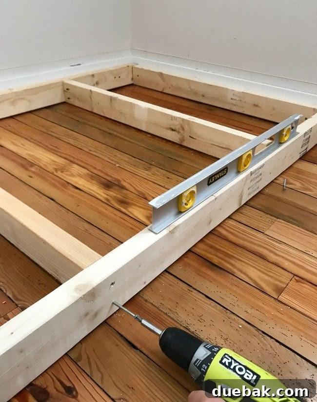 Constructing Bespoke Bunk Beds 9 A long level being used to ensure the base frame of the bottom bunk bed is perfectly horizontal before further construction.