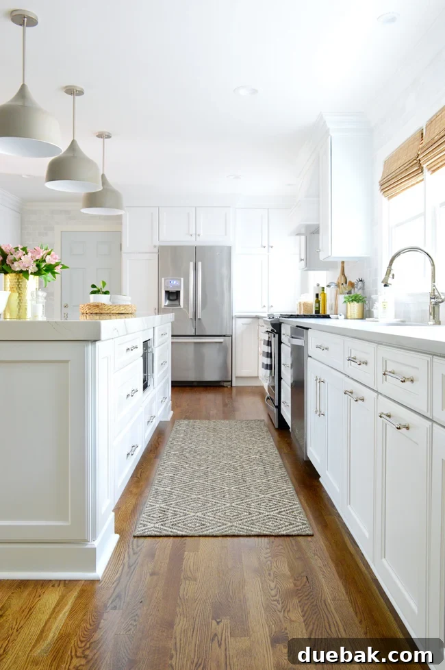 Kitchen with white floor-to-ceiling subway tile extending around a doorway, connecting the spaces