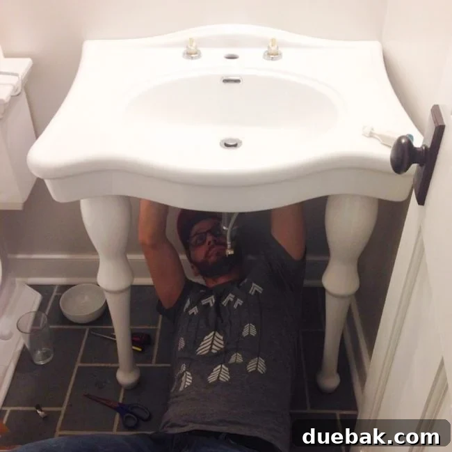 Person hooking up a console sink after renovation