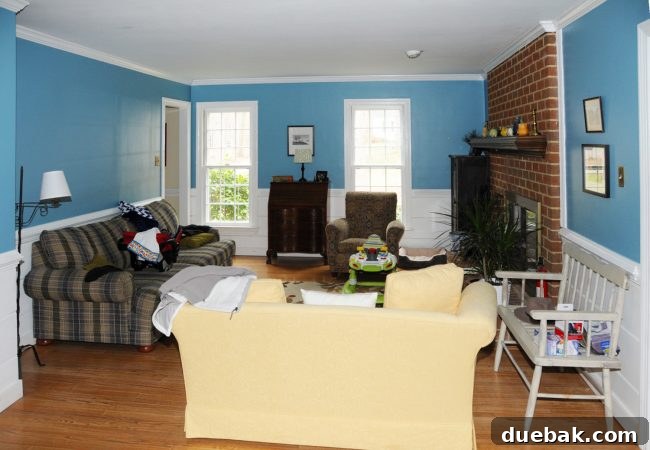 Home Staging Tips: Sell Your House or Simplify Your Life 20 living room before staging with blue walls brick fireplace and lot of furniture, appearing crowded