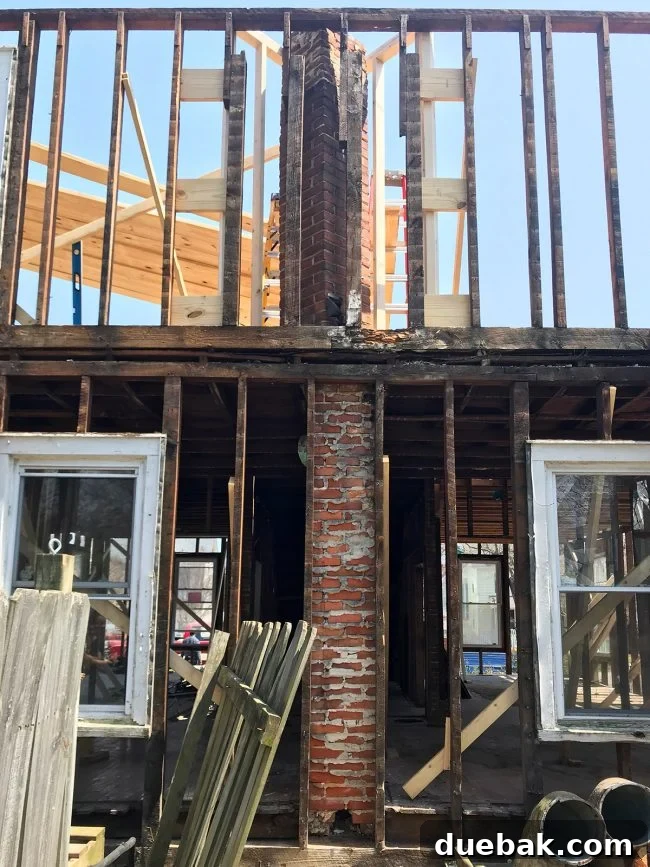 Rear view of duplex showing unusual chimney structure before full removal.